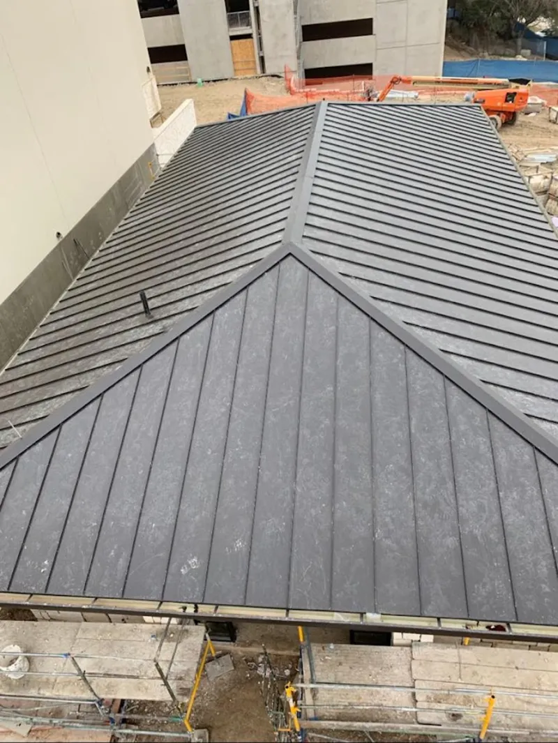 Commercial metal roof construction with crane equipment in Stillwater