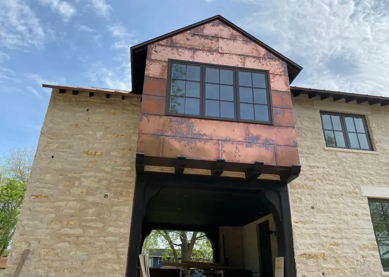 Copper metal panel facade on a stone building for Roof Repair in Stillwater